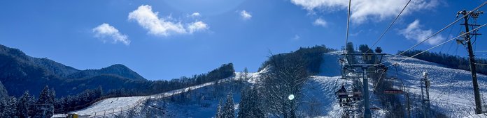 山並みを背にゲレンデを登るペアリフト