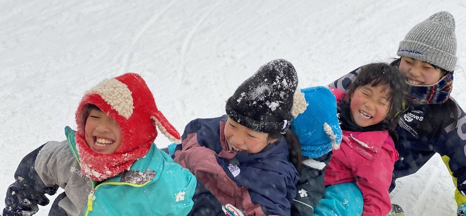 雪山で笑顔を見せる家族連れ