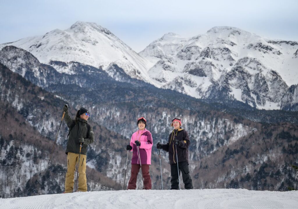 雪山の林の中をスノーシューで歩く4人のグループ