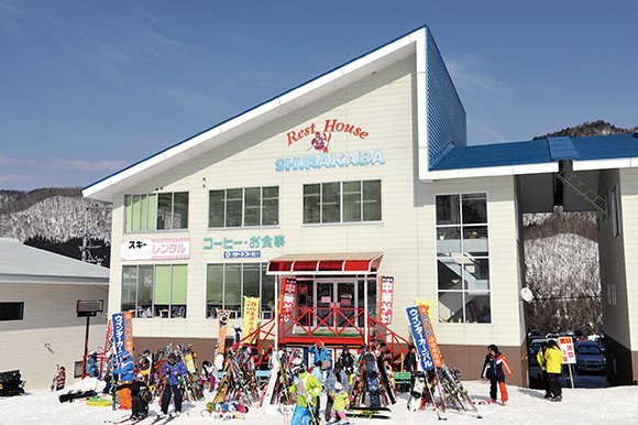 Rest House Shirakaba exterior: white lodge with skiers gathered in front
